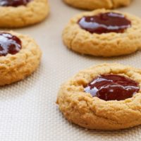 Peanut butter and jelly thumbprint cookies in rows.