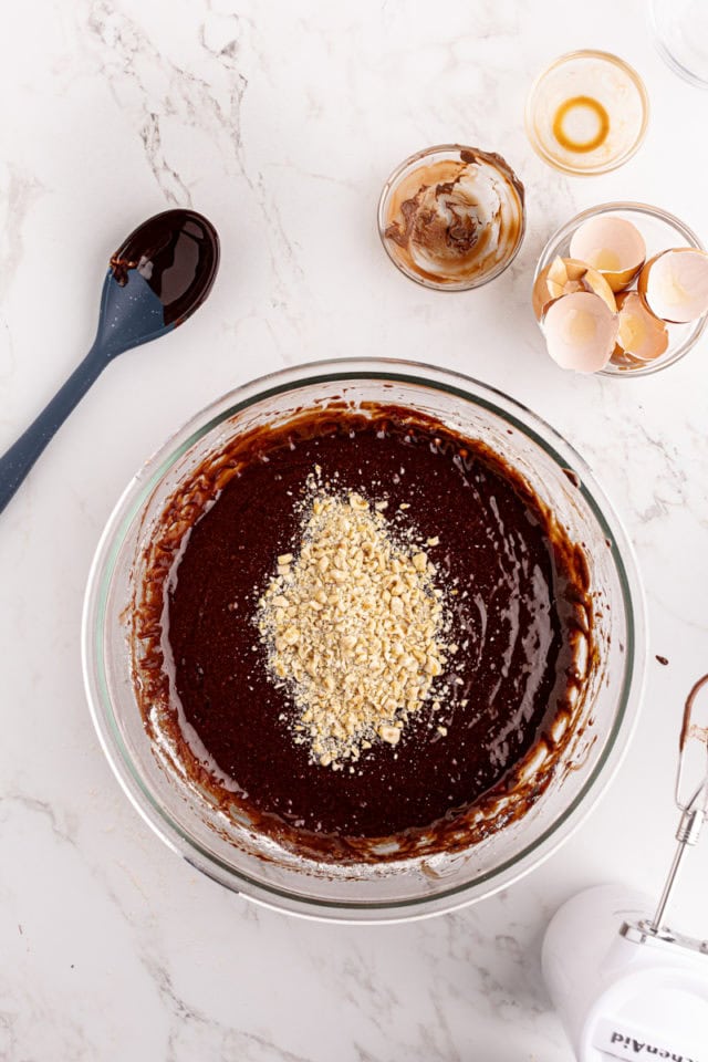 Overhead view of hazelnuts added to brownie batter