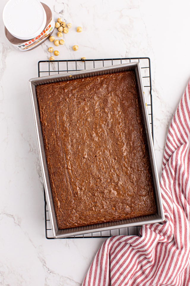 Overhead view of baked Nutella brownies in pan on cooling rack