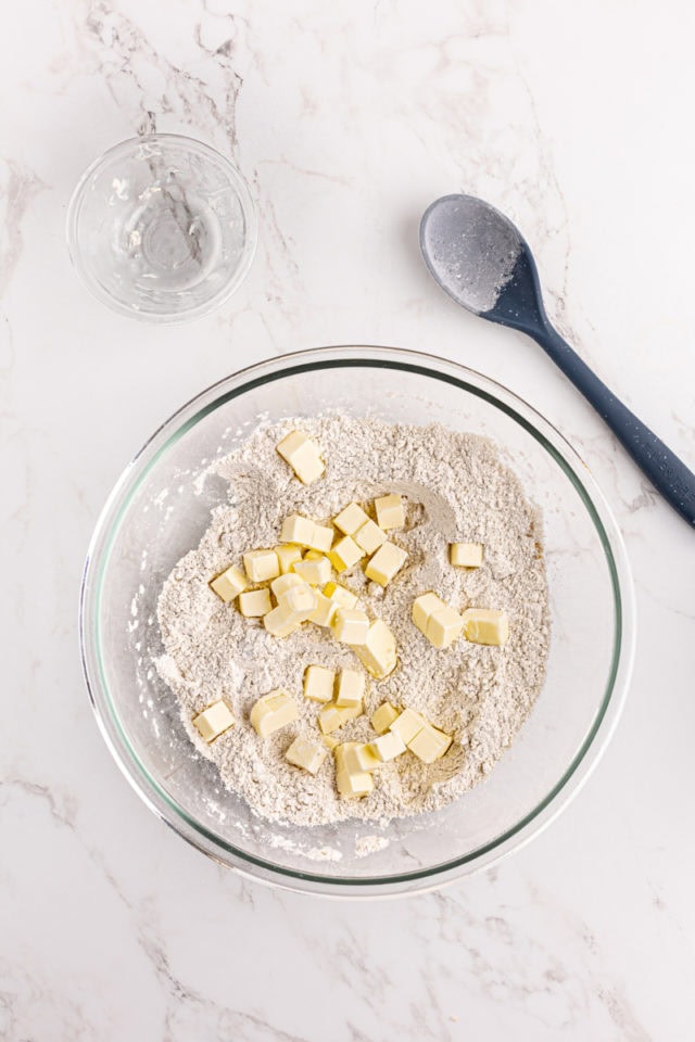 Overhead view of butter added to dry ingredients for shortbread