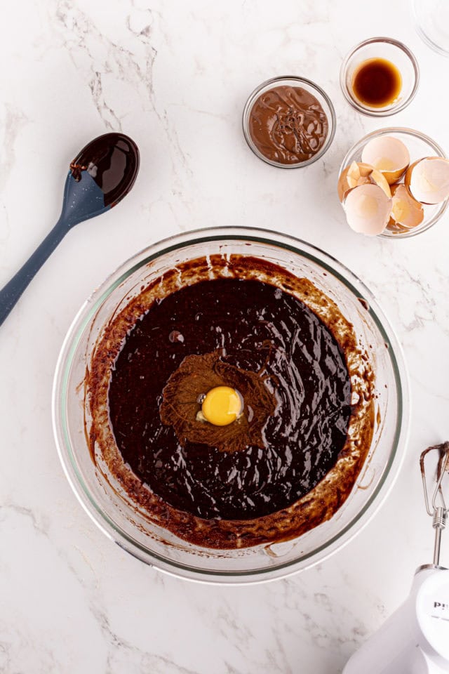 Overhead view of egg added to brownie batter