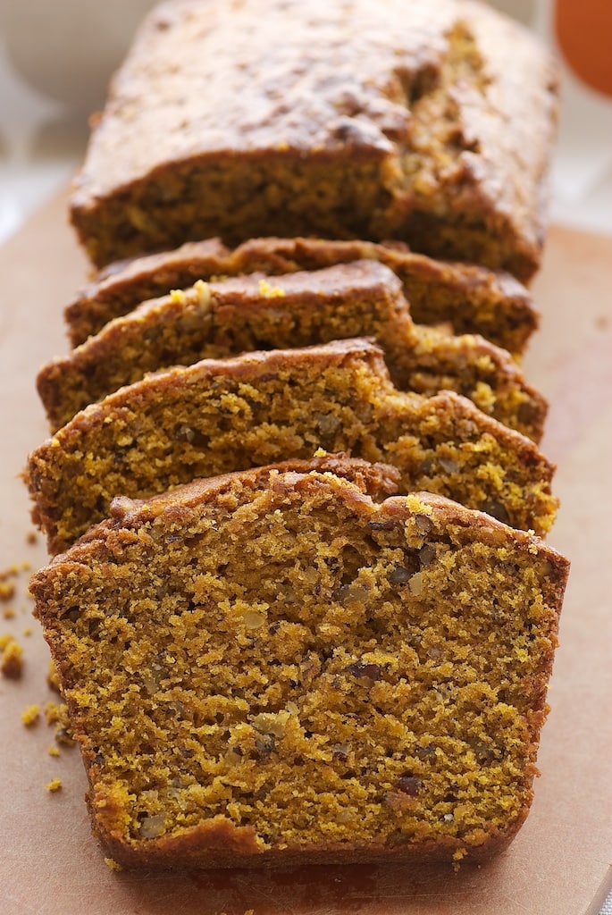 Sliced Pumpkin Pecan Bread on a wooden cutting board.