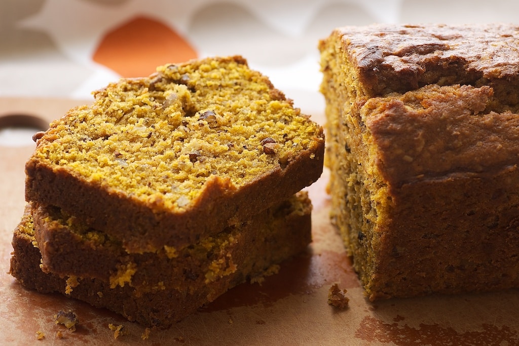 slices of Pumpkin Pecan Bread stacked on a wooden cutting board