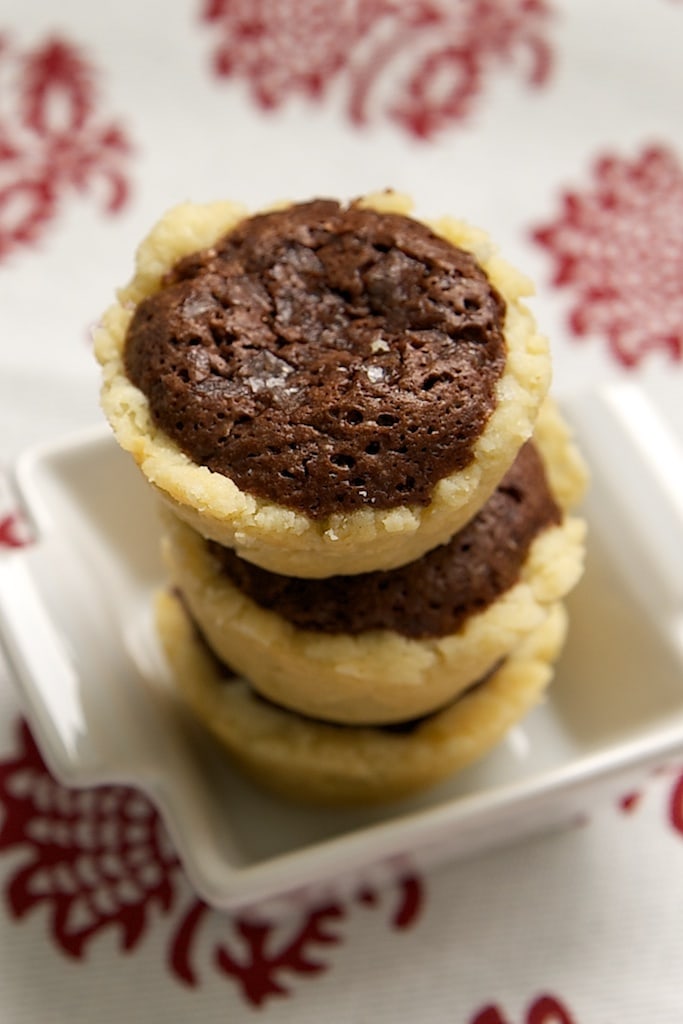 Stack of Salty Brownie Tassies on a small white plate.