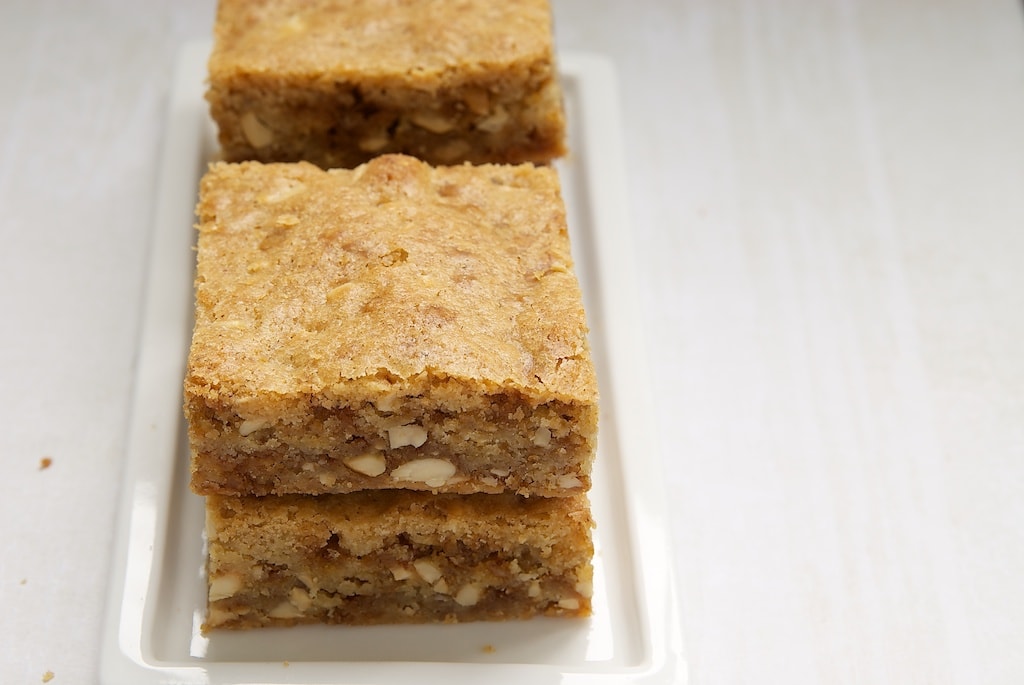 four brown butter blondies on a rectangular white plate