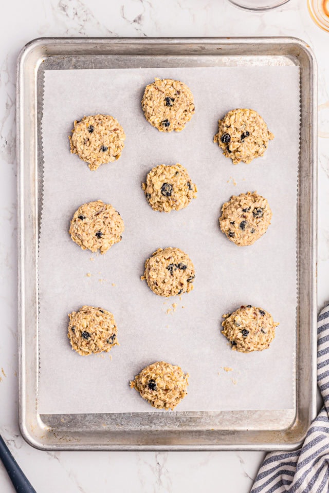 Overhead view of unbaked blueberry oatmeal cookies on parchment-lined baking sheet