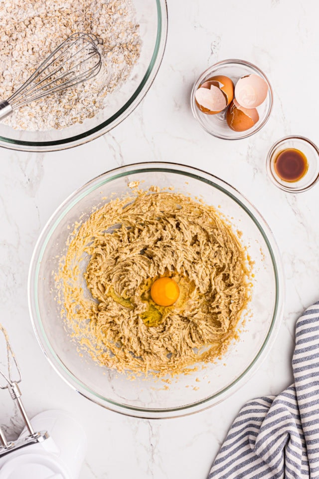 Overhead view of egg added to wet ingredients in bowl