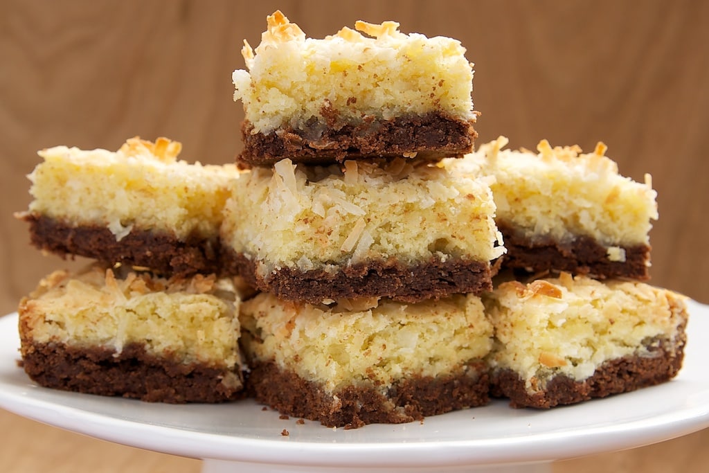 Coconut Bars with Chocolate Shortbread Crust stacked on a white serving pedestal