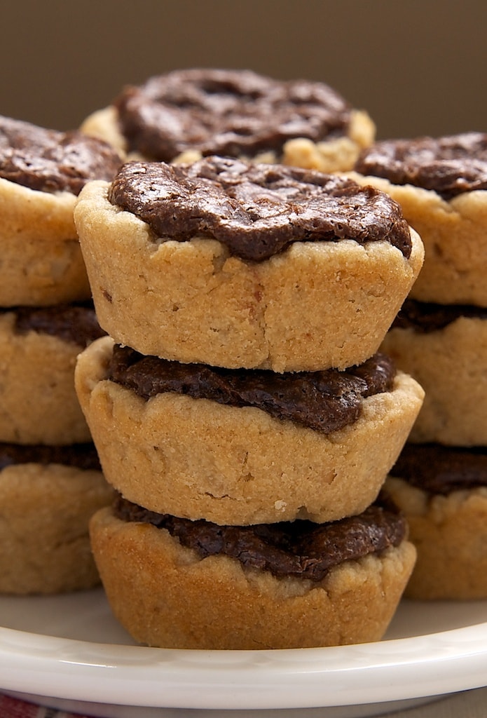 Peanut Butter Fudge Tartlets stacked on a white plate