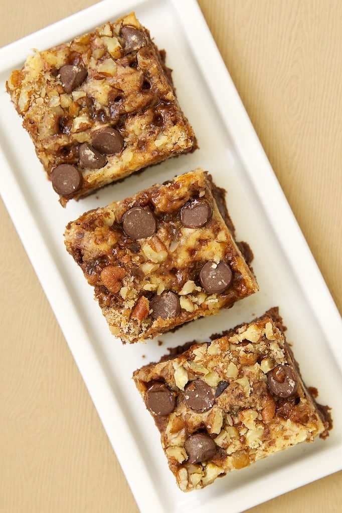 Overhead view of cream cheese brownies with toffee and pecans on rectangular tray