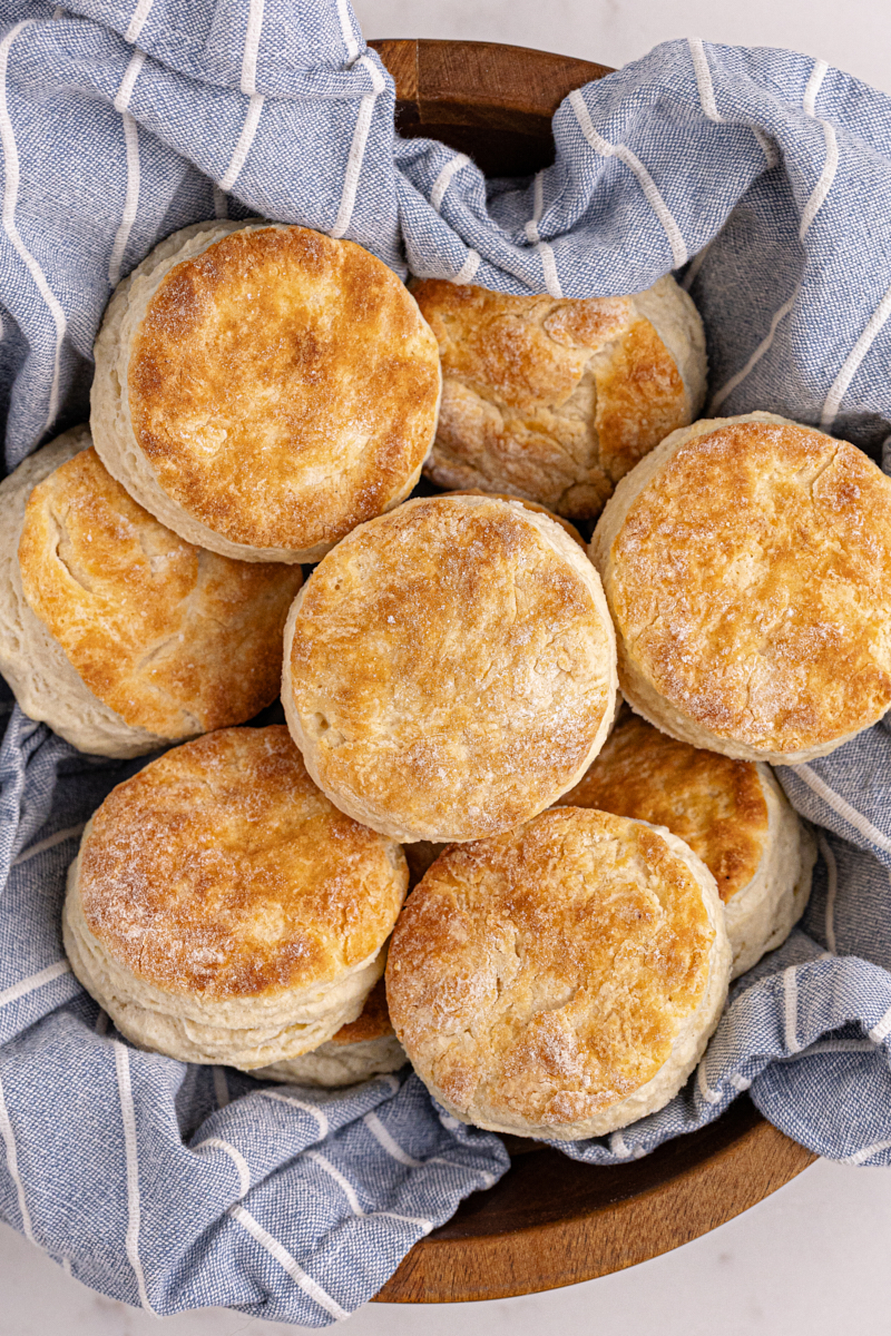 Buttermilk biscuits in wooden bowl lined with tea towel