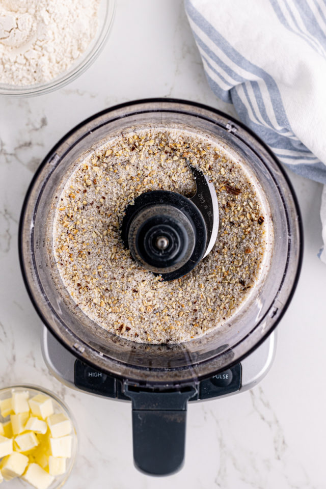 Overhead view of ground almonds and sugar in food processor