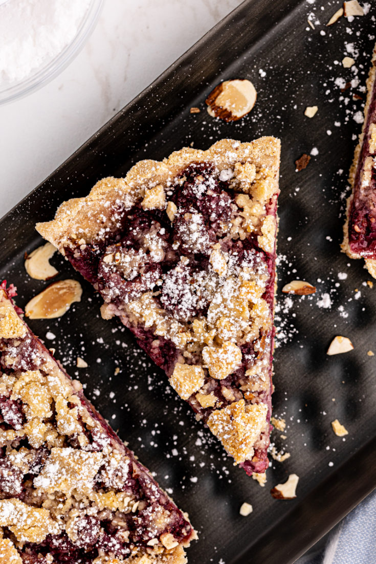 Overhead view of raspberry crumb tart slices on platter