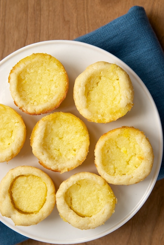 Lemon Chess Tartlets served on a white tray on a blue napkin