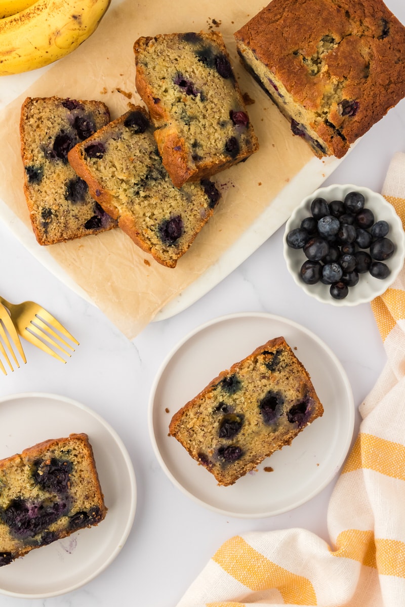 Slices of blueberry banana bread on plates.