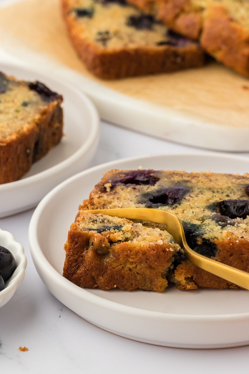 Banana quick bread on a plate with a fork.