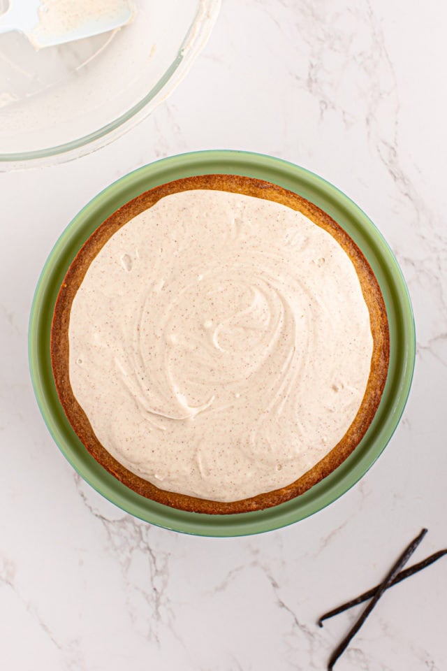 Frosted vanilla bean cake on cake stand