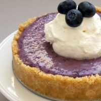 No-Bake Blueberry Cheesecake topped with sweetened whipped cream and blueberries