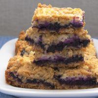 Blueberry Jam-Cream Cheese Bars stacked on a white plate