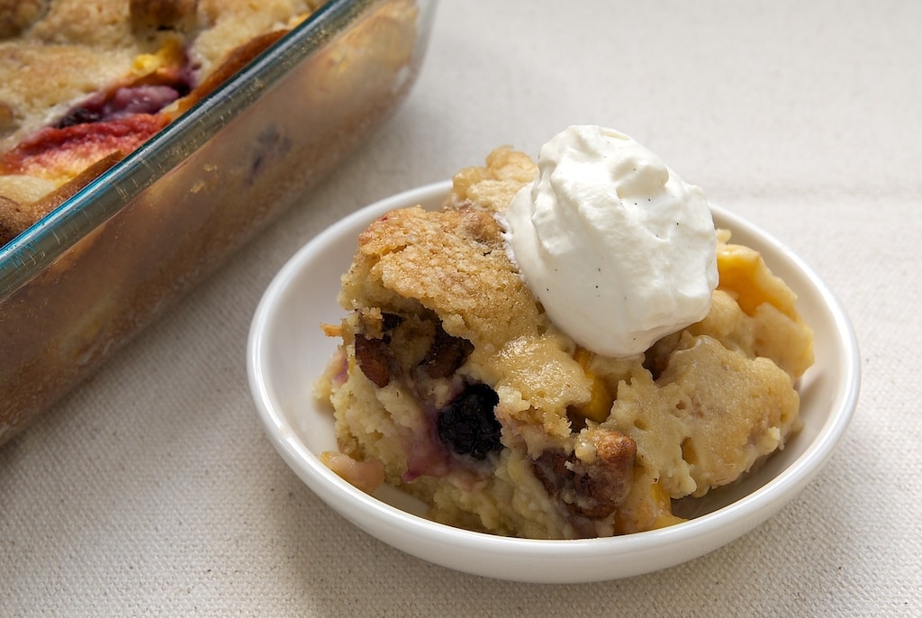 Blackberry Peach Cobbler topped with sweetened whipped cream