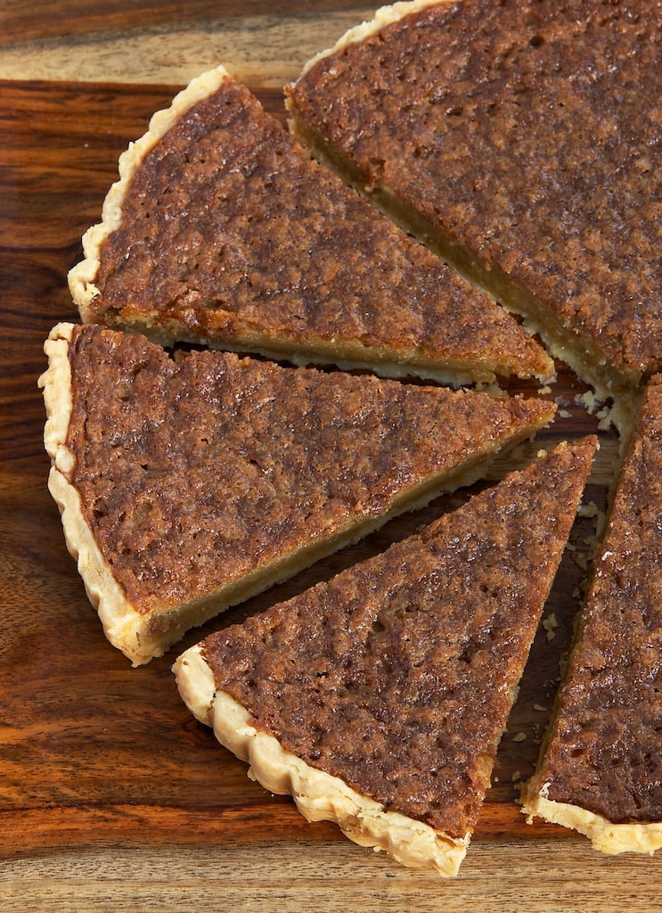 Caramel chess pie on cutting board with 3 pieces cut