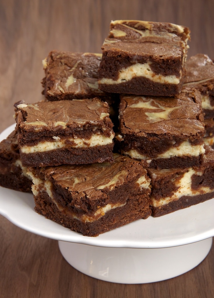 Stack of bourbon cream cheese brownies on white cake stand