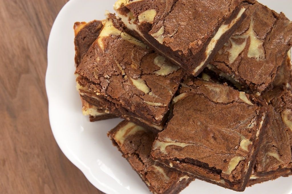 Closeup of stack of bourbon cream cheese brownies on white plate