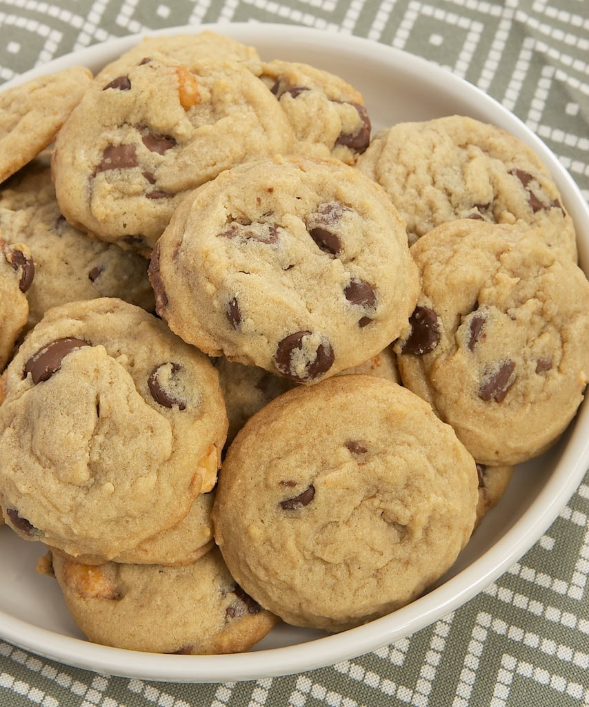 loaded peanut butter chocolate chip cookies piled on a white plate