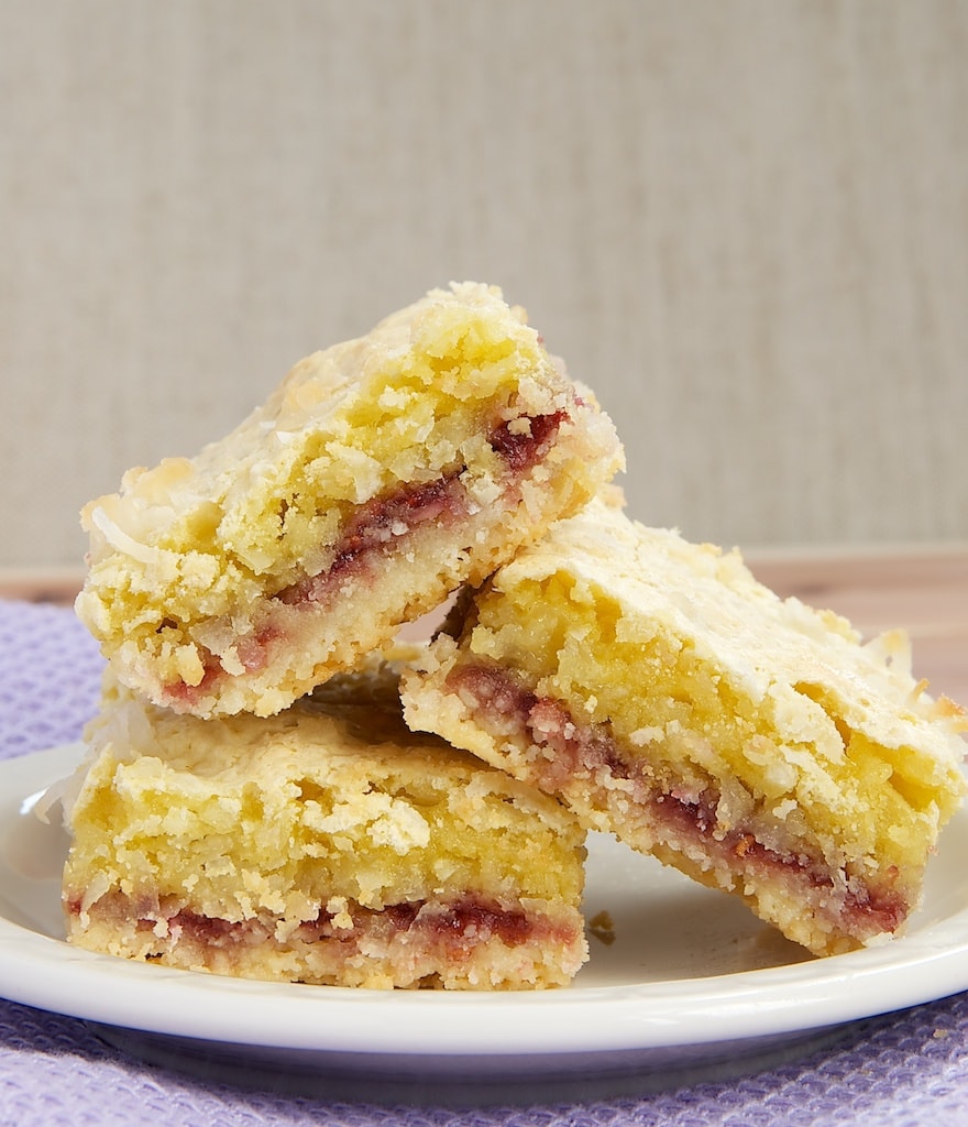 Coconut-Rasbperry Bars feature an almond shortbread crust, delicious raspberry preserves, and a chewy coconut topping.