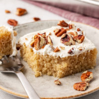 Slice of brown butter Texas sheet cake on plate with bite on fork