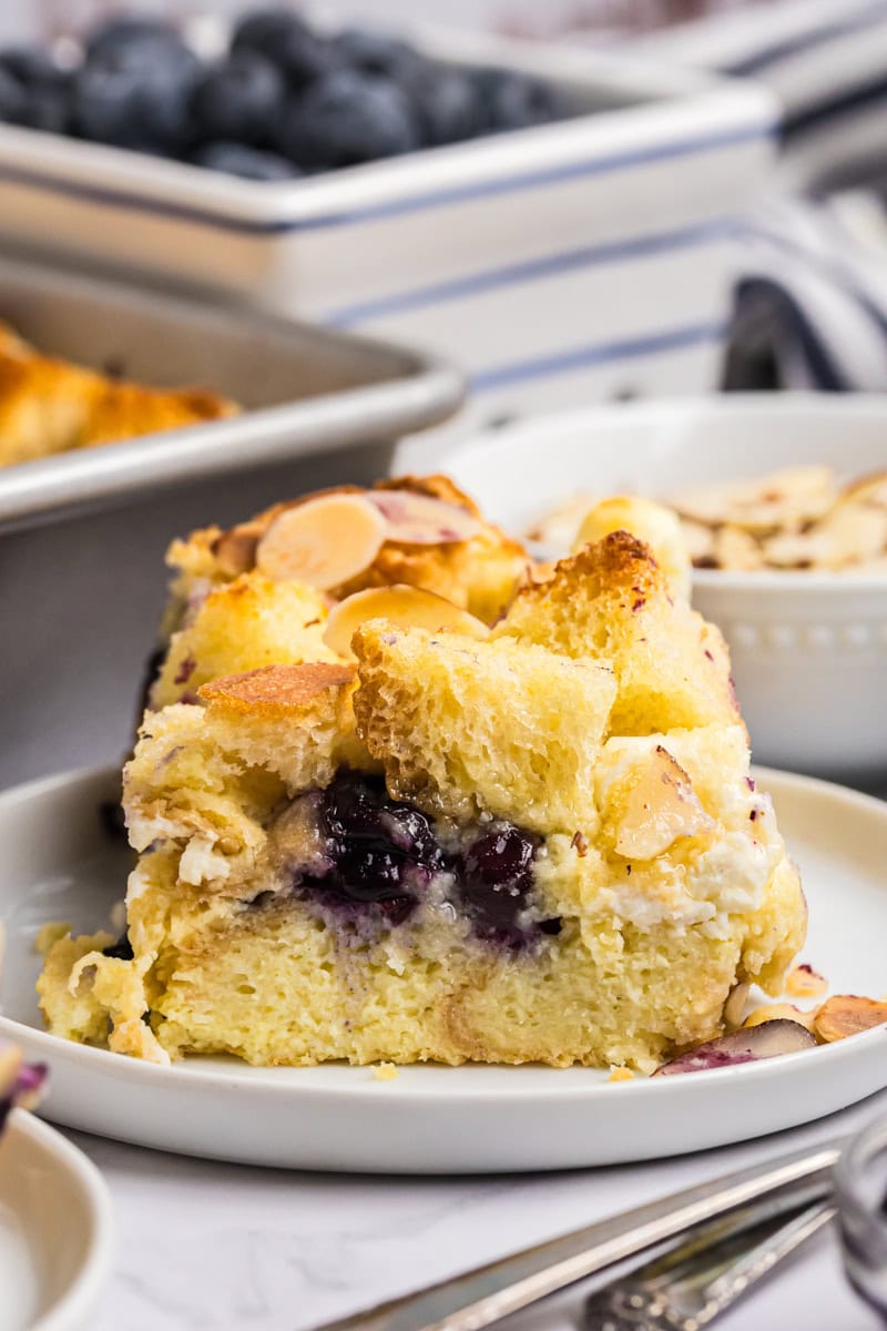 slice of blueberry bread pudding with cream cheese, soft custard and juicy blueberries visible