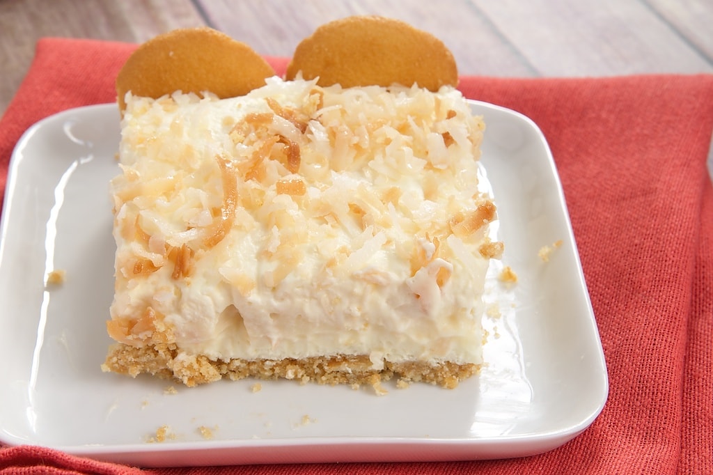 slice of Coconut Cream Pie Bars on a square white plate