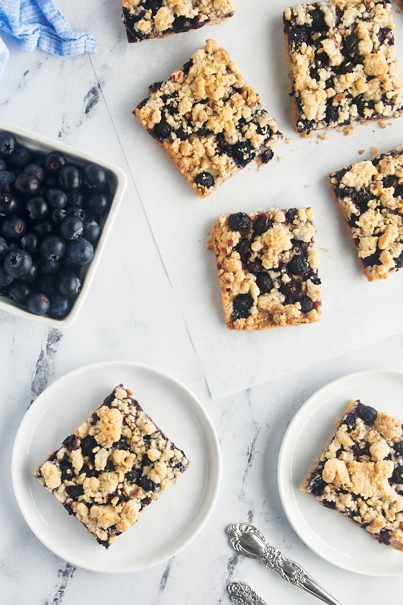 Blueberry pie bars on small white plates.