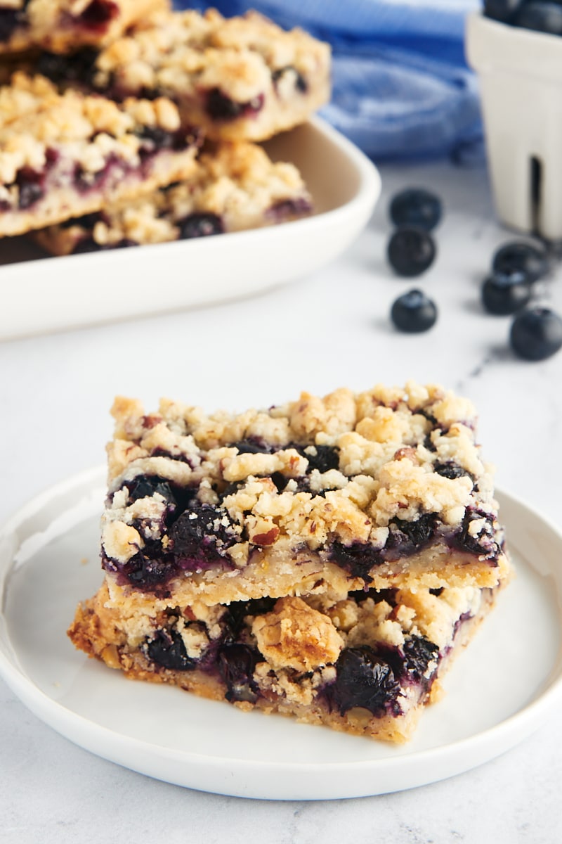 Stacked lemon blueberry bars on a plate.