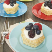 Berries and Cream Tartlets served on colorful plates