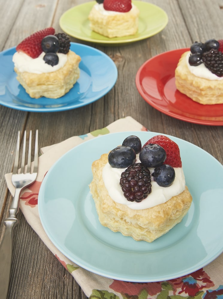 Berries and Cream Tartlets served on colorful plates