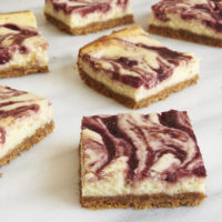 servings of Cherry Cheesecake Bars on a marble platter