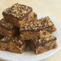 Chocolate Chip Ganache Blondies stacked on a blue plate