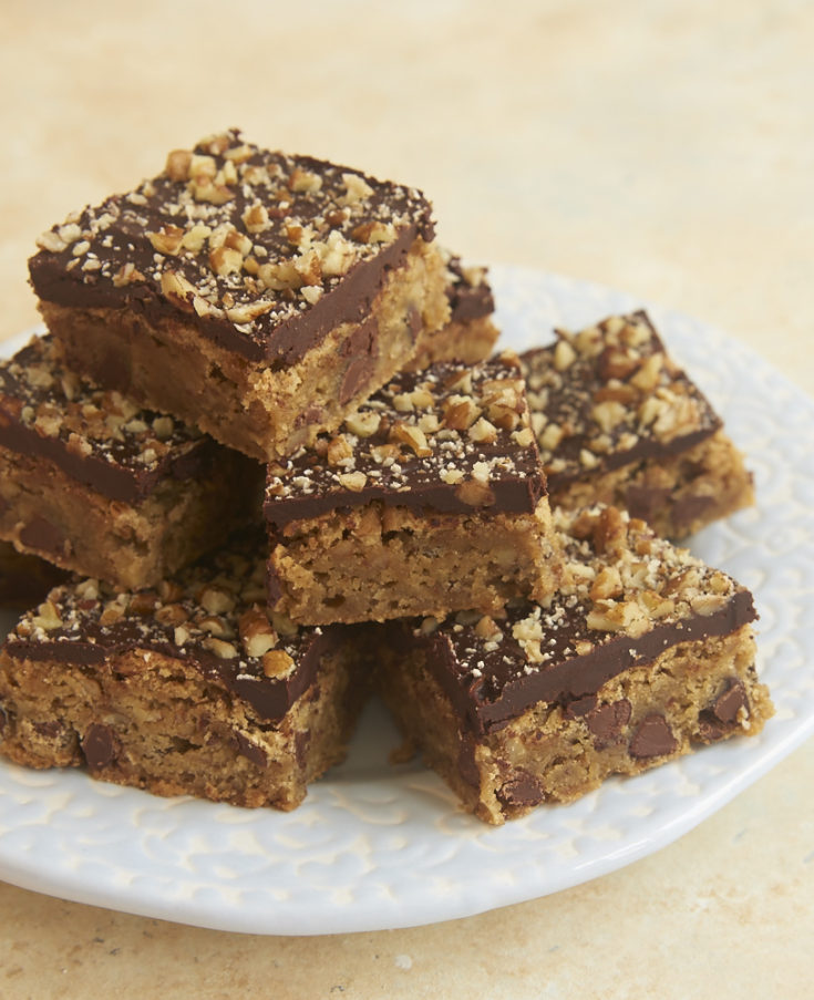 Chocolate Chip Ganache Blondies stacked on a blue plate