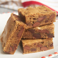 stack of Double Chocolate Chunk Blondies on a red-rimmed white plate