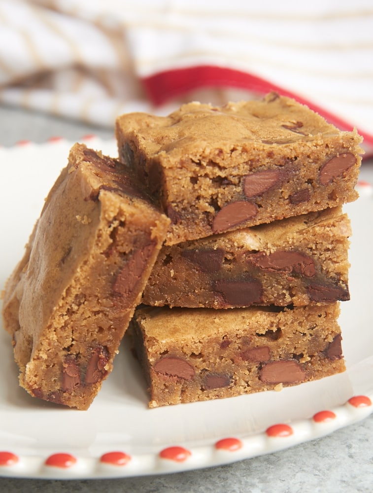 stack of Double Chocolate Chunk Blondies on a red-rimmed white plate