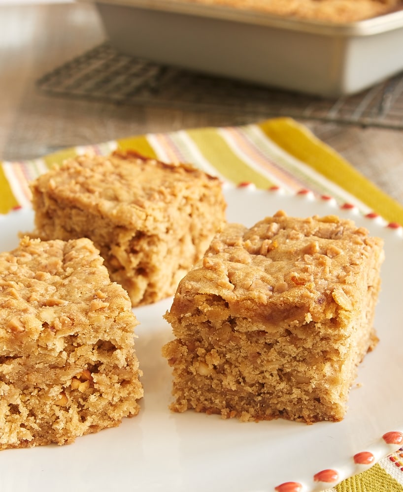 slices of Peanut Butter Toffee Snack Cake on a red-rimmed white plate