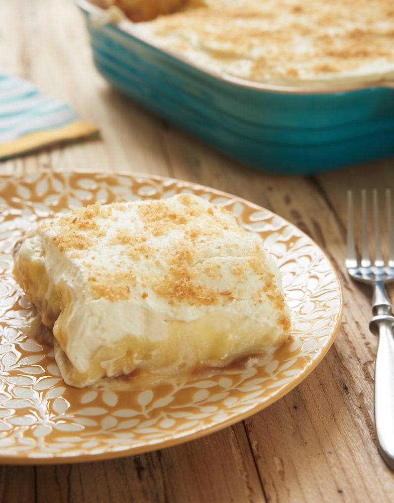 A square of banana pudding on a plate next to a fork.