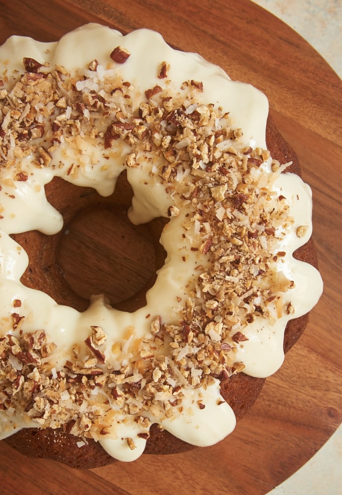 Italian Cream Bundt Cake topped with a cream cheese glaze, pecans, and toasted coconut