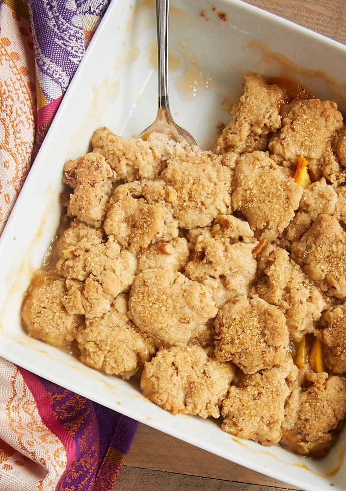 overhead view of peach cobbler in a white baking dish