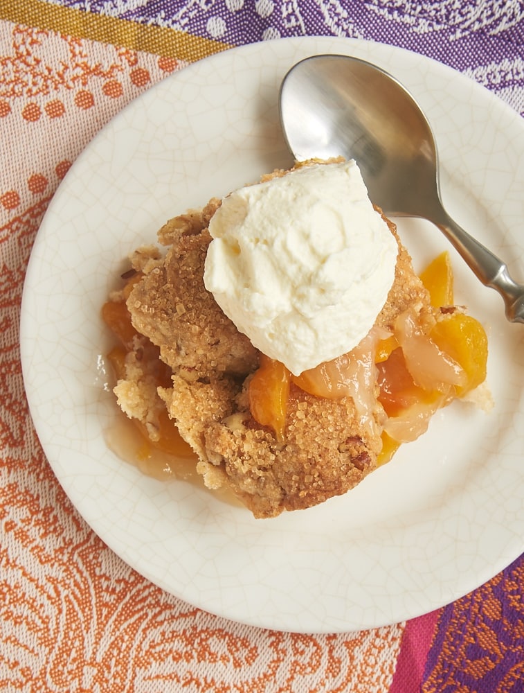 Ginger Pecan Peach Cobbler topped with sweetened whipped cream