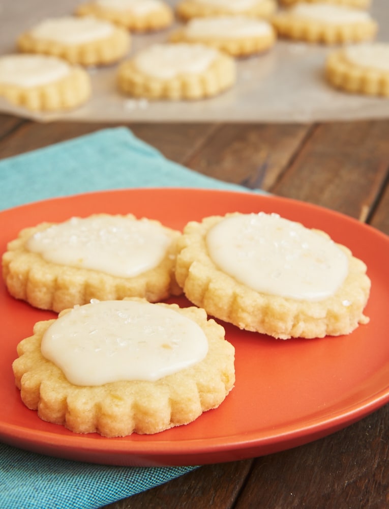 Peach shortbread cookies on an orange plate.