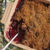 Cherry Berry Crumble in square baking dish with spoon