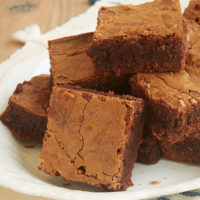 A pyramid-shaped stack of Milk Chocolate Brownies on a plate.