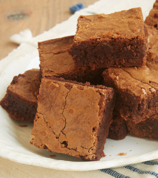 A pyramid-shaped stack of Milk Chocolate Brownies on a plate.